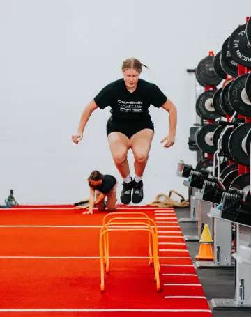 Iron Performance Center Woman Jumping over Hurdles